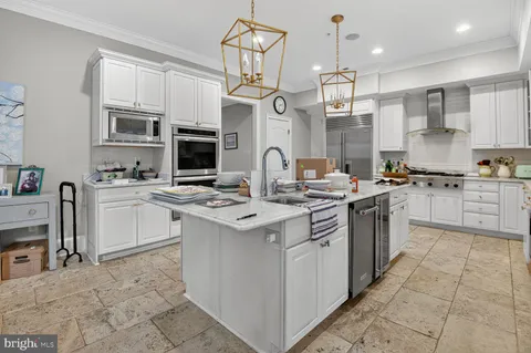 a kitchen with stainless steel appliances a sink stove and cabinets