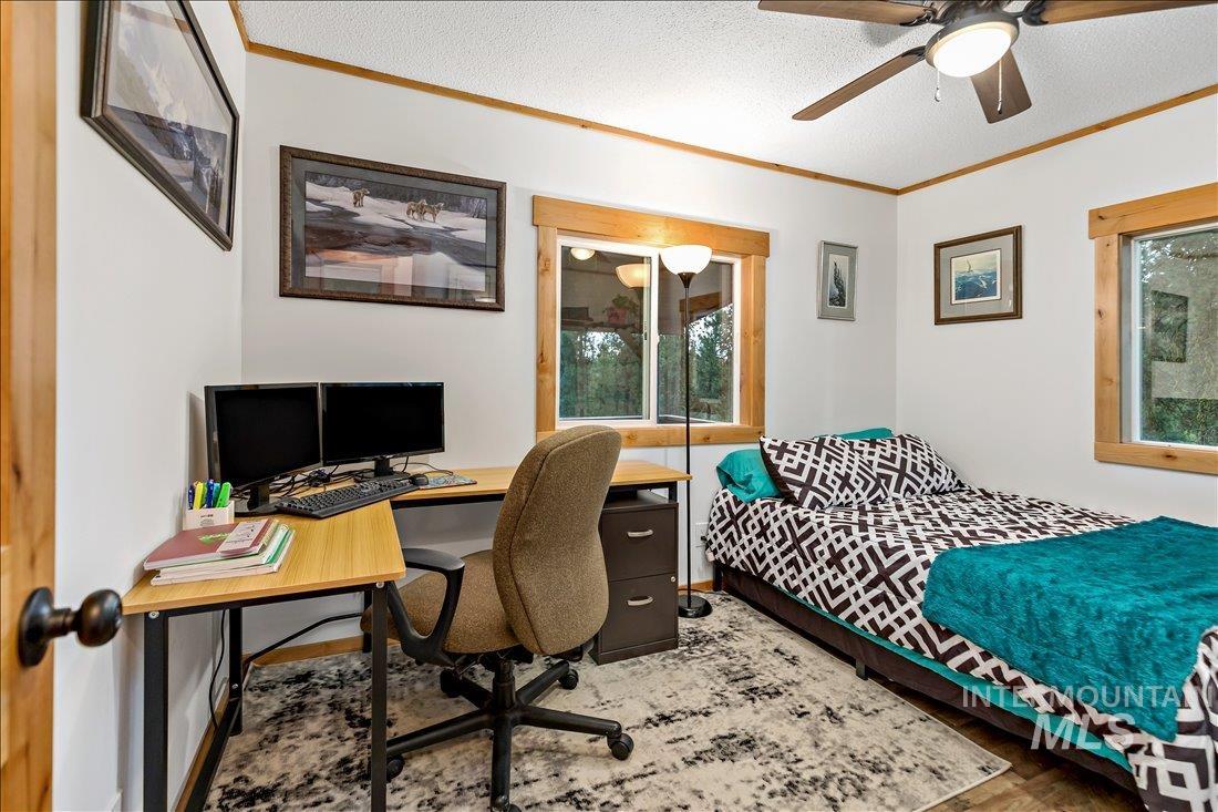 79 Sunset Loop Cascade, ID 83611 - Photo 25 of 44 Room featuring two windows with wood trim, a ceiling fan with integrated lighting, and wood-finish flooring