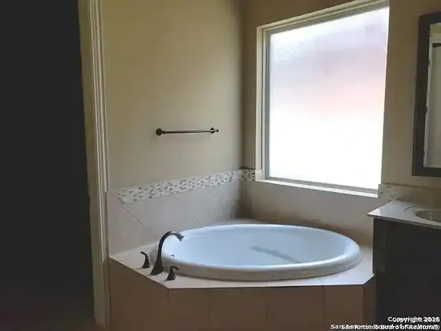 a bathroom with a sink a toilet a window and a mirror