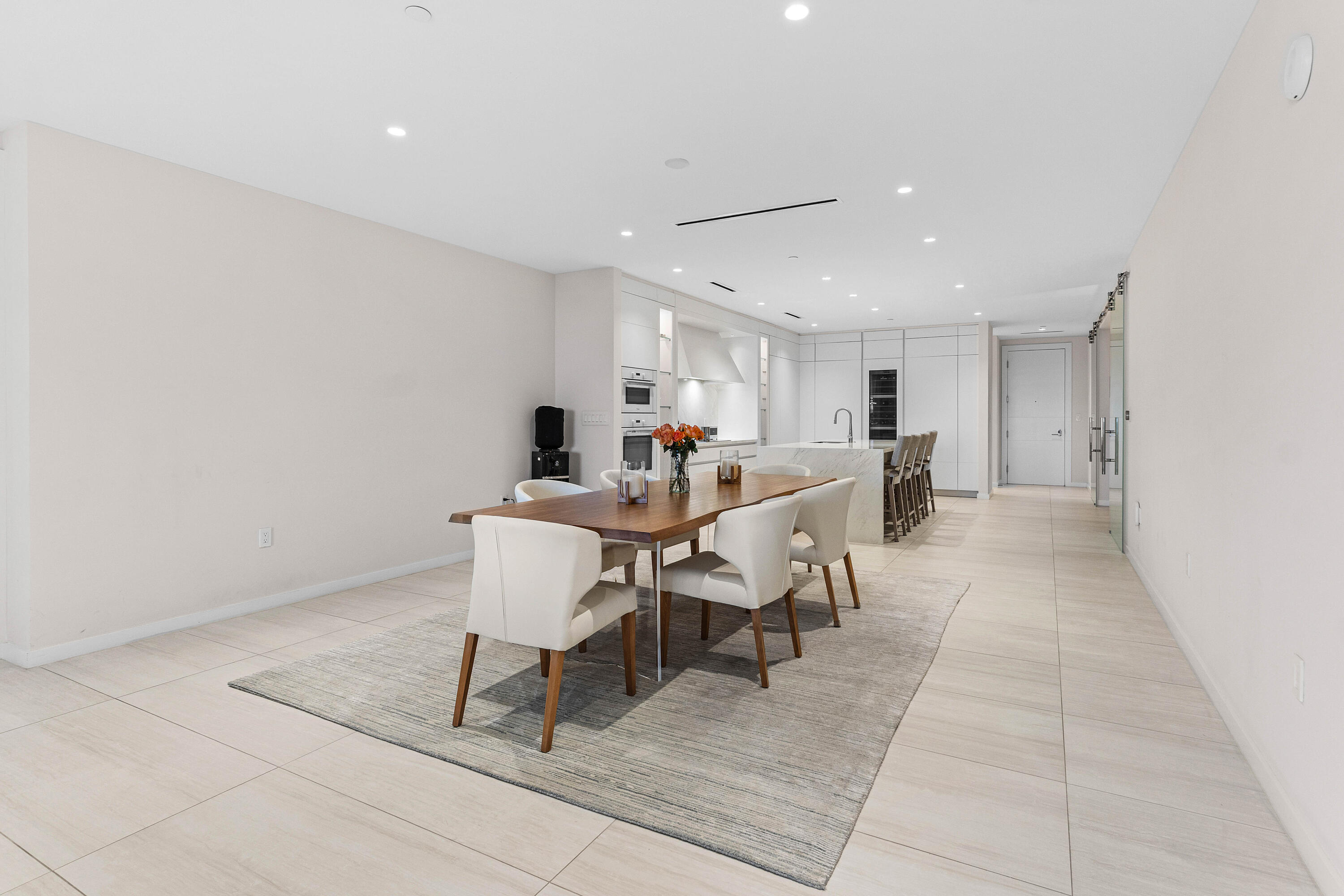 200 Southeast Mizner Boulevard, Unit 707 Boca Raton, FL 33432 - Photo 10 of 119 a living room with furniture and a dining table with kitchen view