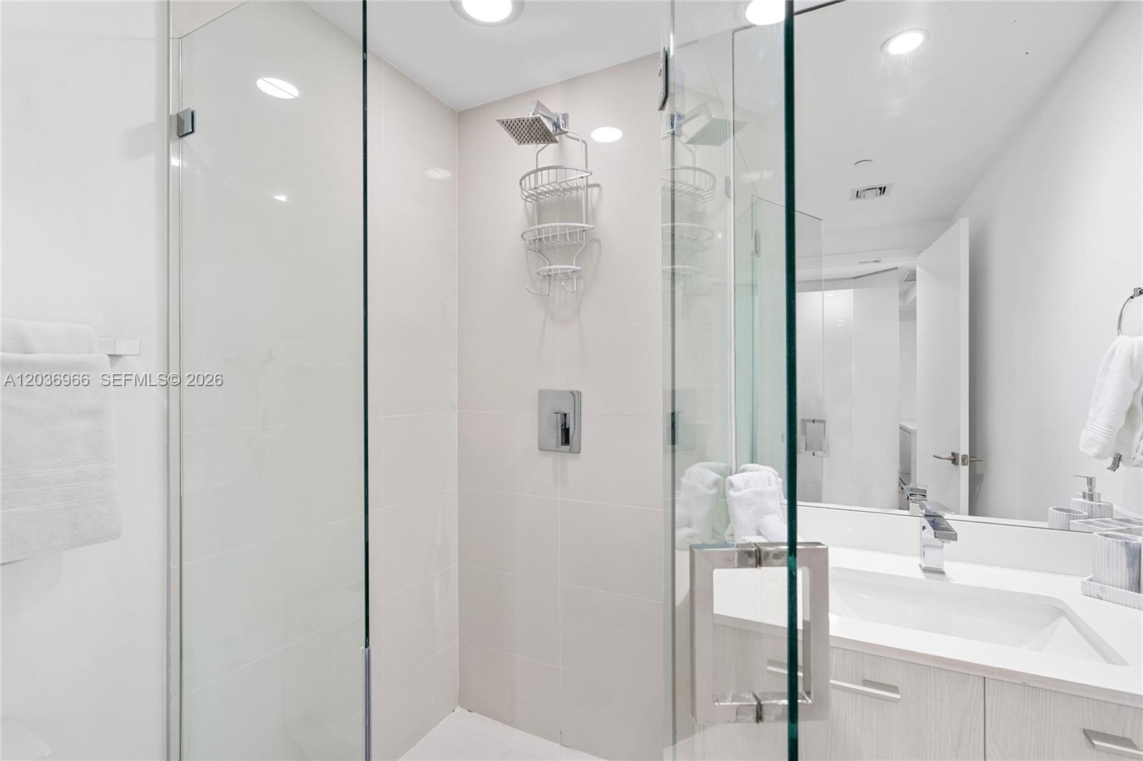 55 Southwest 9th Street, Unit 1904 Miami, FL 33130 - Photo 18 of 66 a bathroom with a double vanity sink mirror and shower