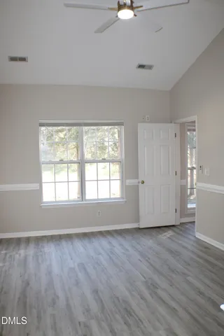 a view of empty room with wooden floor