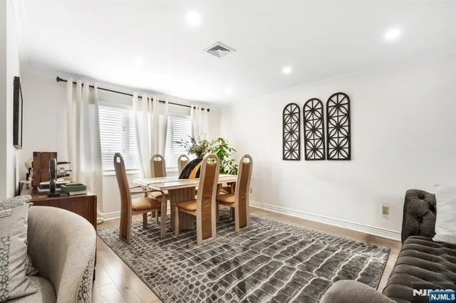 a kitchen with stainless steel appliances granite countertop a table chairs and a refrigerator