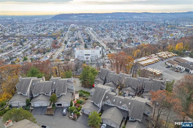 a front view of a house with a yard and mountain view in back