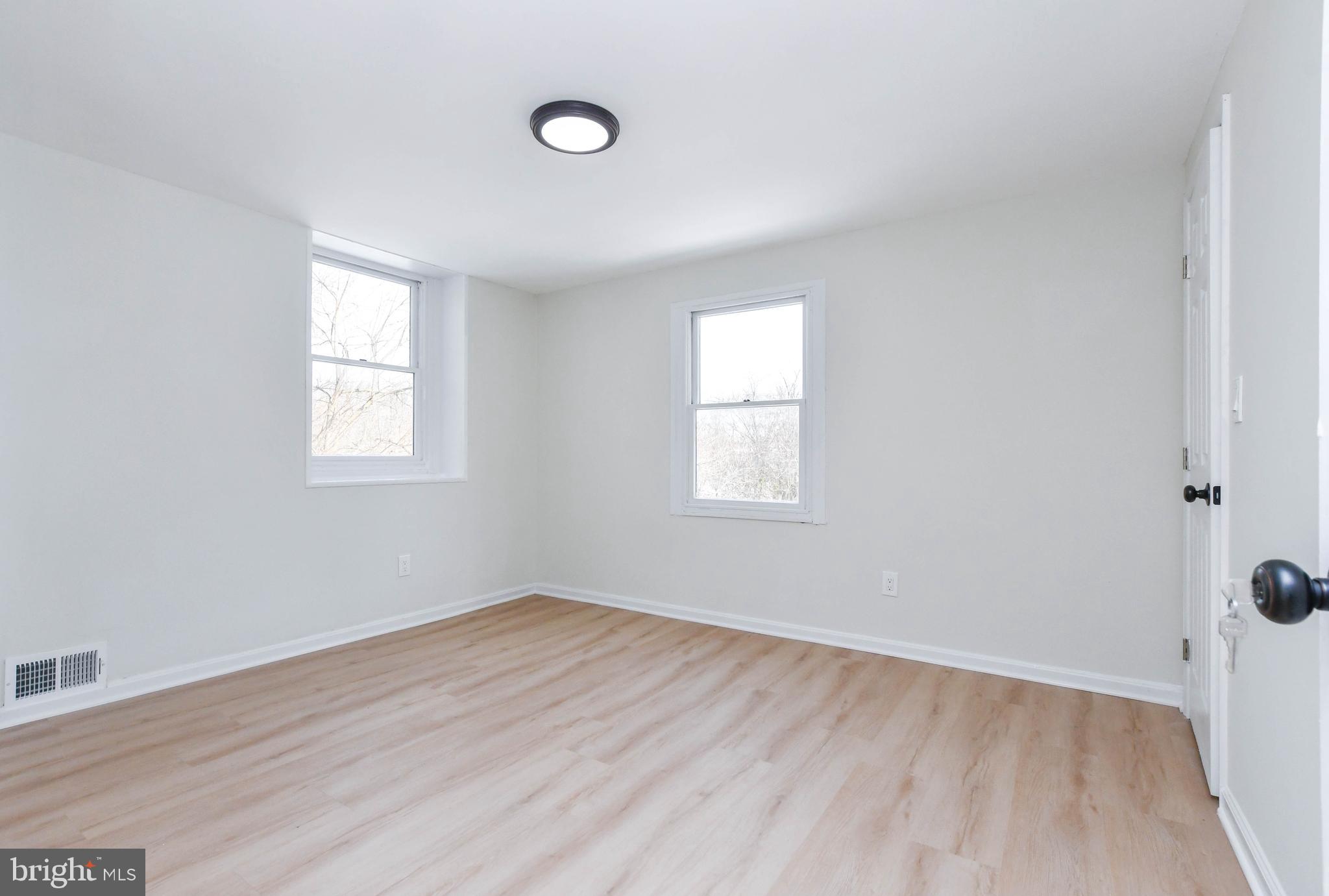 8130 Sheriff Road Landover, MD 20785 - Photo 21 of 36 an empty room with wooden floor and windows