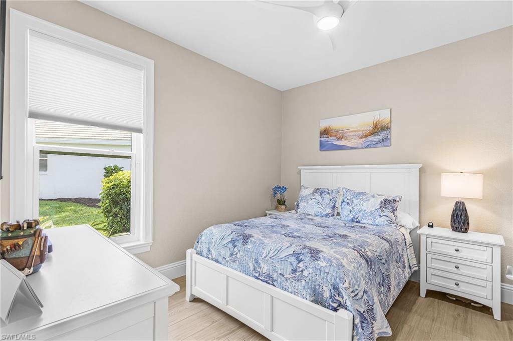 1799 Langford Lane Naples, FL 34109 - Photo 12 of 25 a bedroom with a large bed and a painting on the wall