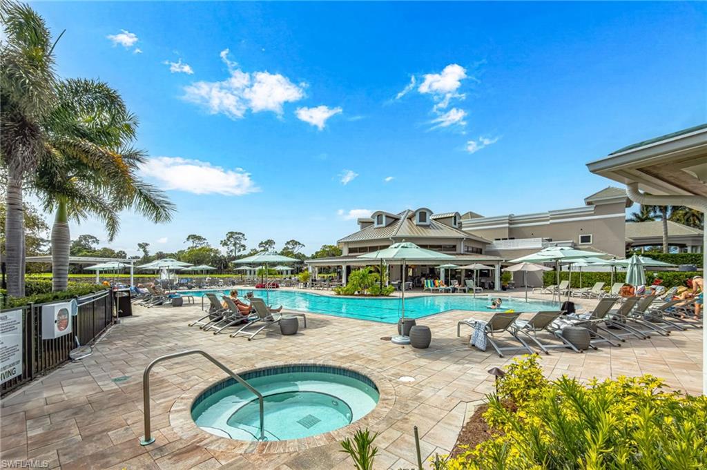 1799 Langford Lane Naples, FL 34109 - Photo 22 of 25 a view of a swimming pool with a patio and a garden