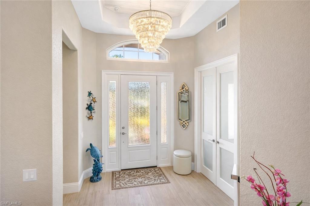 1799 Langford Lane Naples, FL 34109 - Photo 4 of 25 a view of a hallway with wooden floor and windows