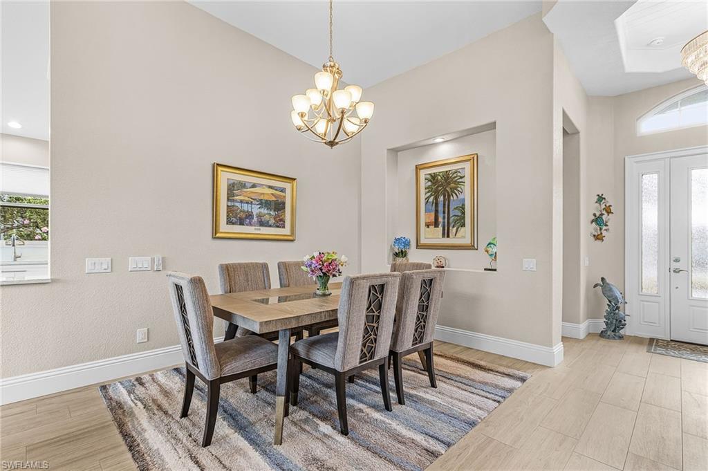 1799 Langford Lane Naples, FL 34109 - Photo 5 of 25 a view of a dining room with furniture and wooden floor