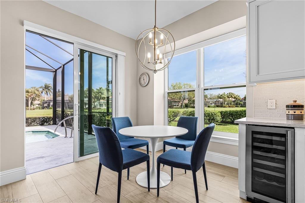 1799 Langford Lane Naples, FL 34109 - Photo 8 of 25 a dining room with furniture a chandelier and wooden floor