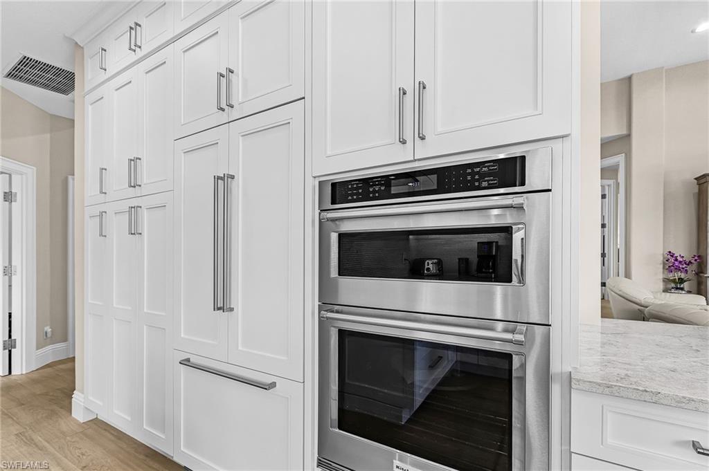 1799 Langford Lane Naples, FL 34109 - Photo 10 of 25 a kitchen with white cabinets and stainless steel appliances