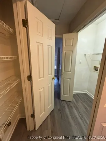 a view of a hallway with wooden floor and staircase