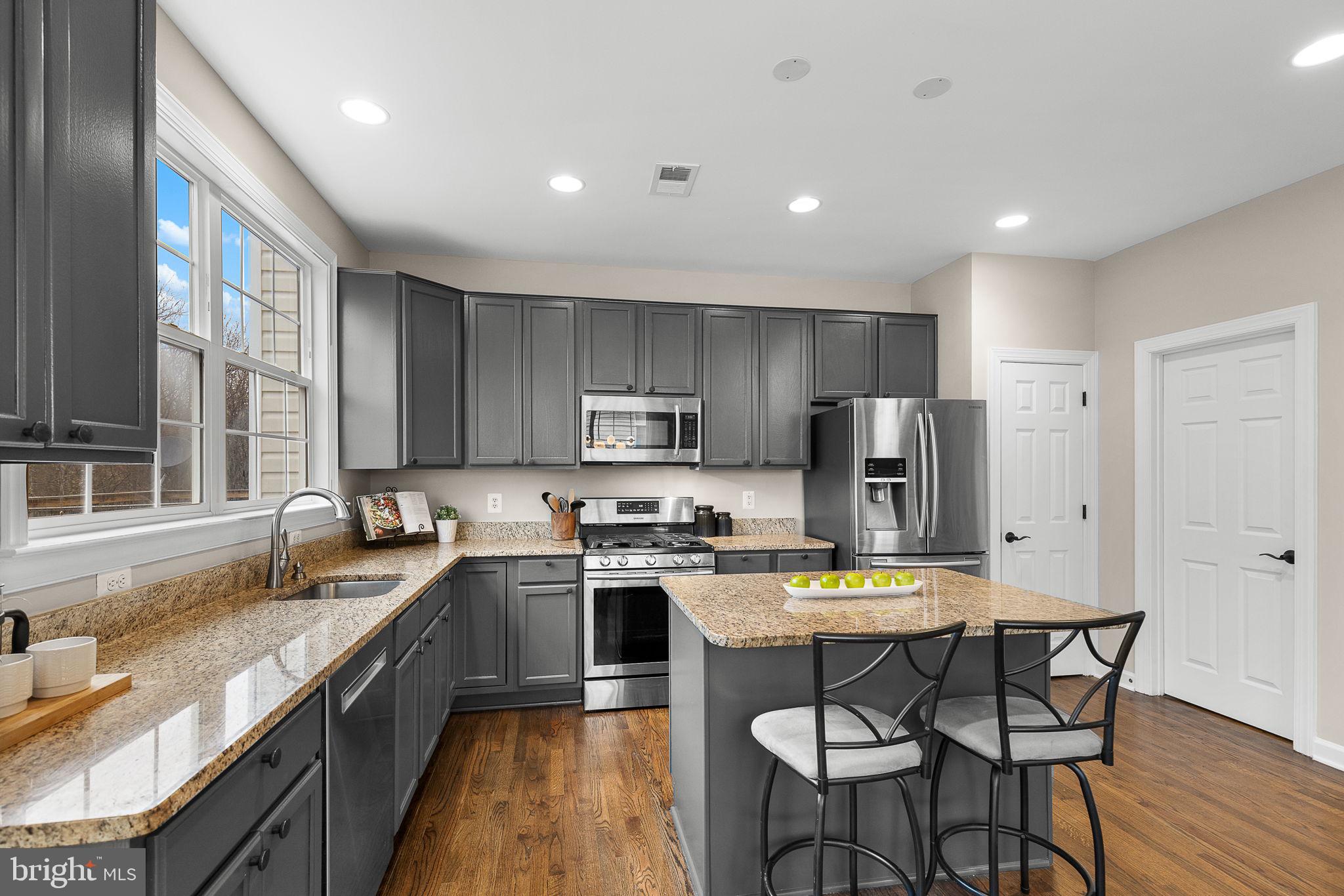 15686 Avocet Loop Woodbridge, VA 22191 - Photo 10 of 33 a kitchen with stainless steel appliances granite countertop a stove top oven a sink dishwasher a dining table and chairs