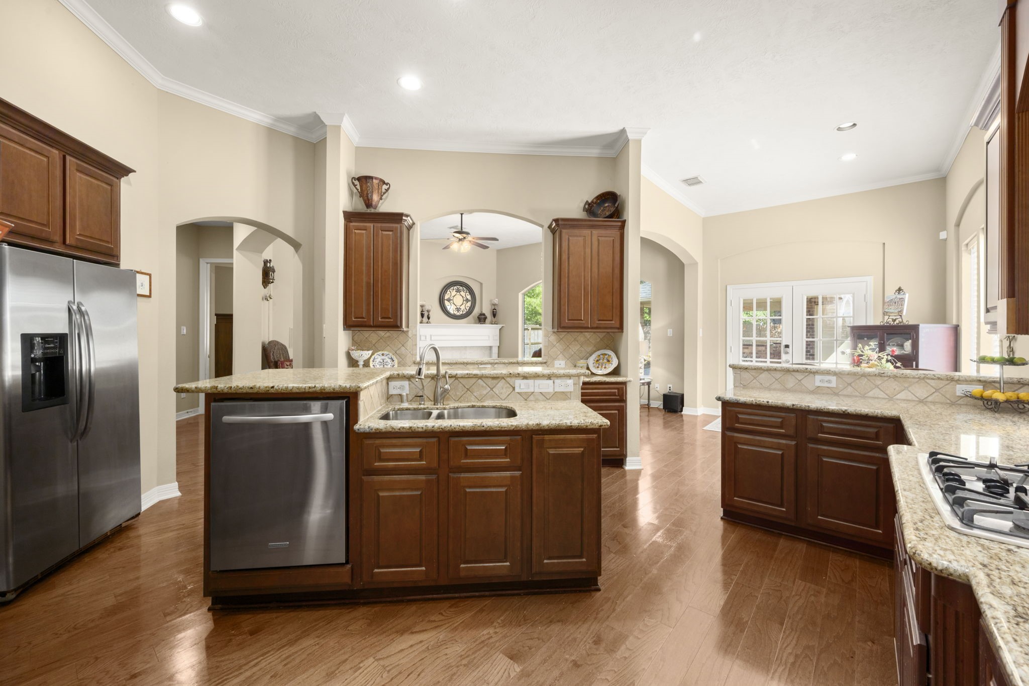 19902 Tidy Tips Lane Spring, TX 77379 - Photo 23 of 50 a kitchen with stainless steel appliances granite countertop a stove a sink dishwasher a refrigerator and a stove with wooden floor