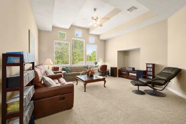 a spacious bedroom with a bed a couch and a chandelier