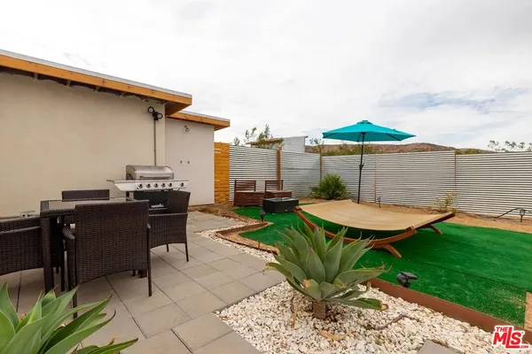 a view of a patio with table and chairs under an umbrella