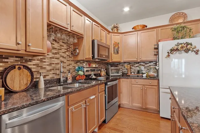 a kitchen with stainless steel appliances granite countertop a sink a stove and cabinets