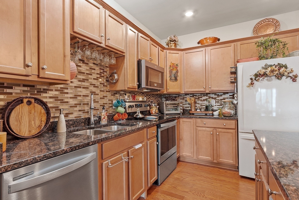 200 Martins Landing, Unit 102 North Reading, MA 01864 - Photo 11 of 33 a kitchen with stainless steel appliances granite countertop a sink a stove and cabinets