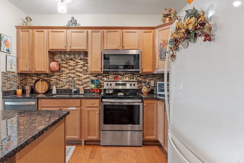 200 Martins Landing, Unit 102 North Reading, MA 01864 - Photo 13 of 33 a kitchen with stainless steel appliances granite countertop a stove a sink and a microwave