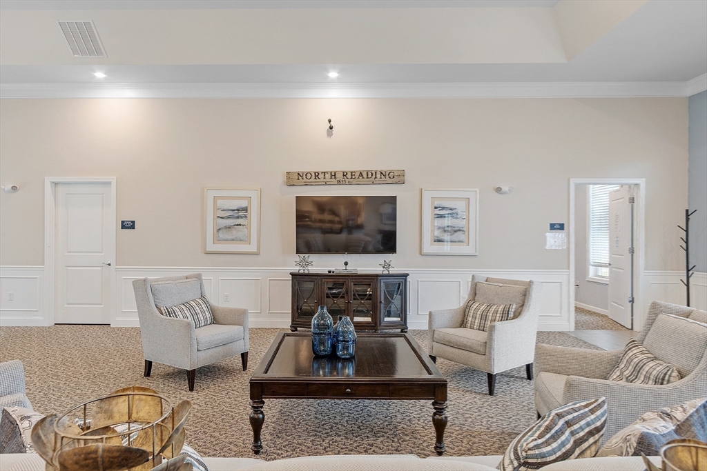 200 Martins Landing, Unit 102 North Reading, MA 01864 - Photo 28 of 33 a living room with furniture a rug and a flat screen tv