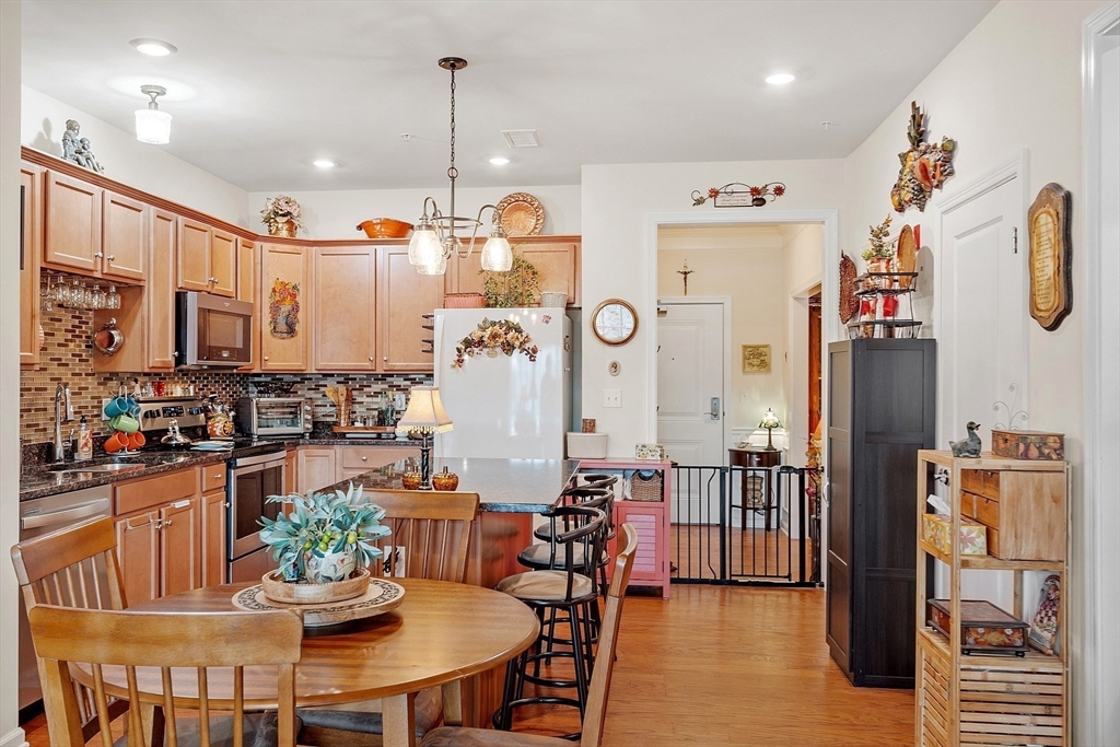 200 Martins Landing, Unit 102 North Reading, MA 01864 - Photo 8 of 33 a view of a dining room and livingroom with furniture wooden floor a chandelier