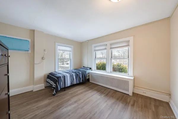 a spacious bedroom with a balcony a bed and wooden floor