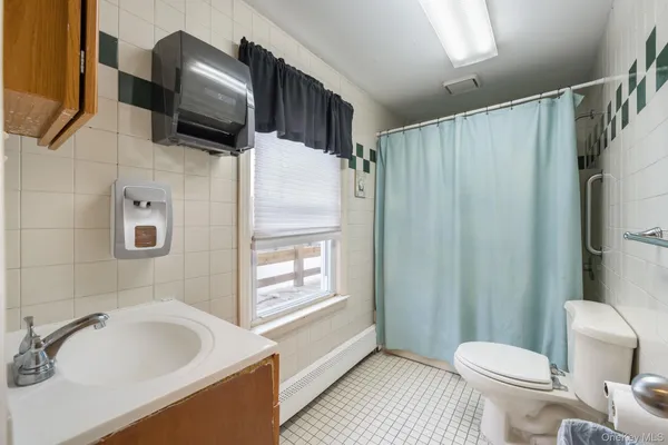 a bathroom with a sink toilet a mirror and shower