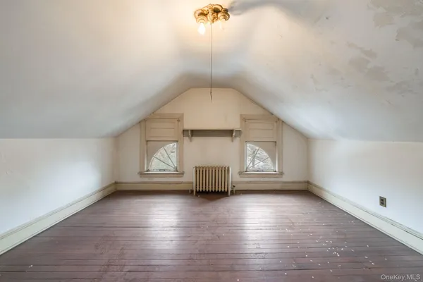 a view of empty room with wooden floor and window
