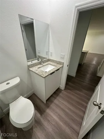 a bathroom with a granite countertop toilet and a sink
