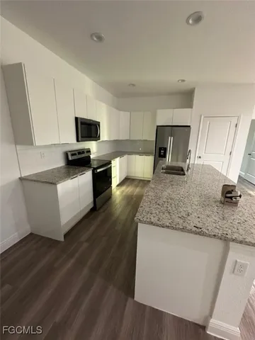 a kitchen with stainless steel appliances granite countertop a sink a stove top oven a counter space and cabinets