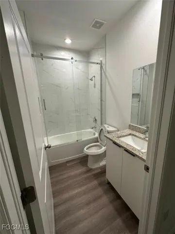 a bathroom with a granite countertop sink toilet and shower