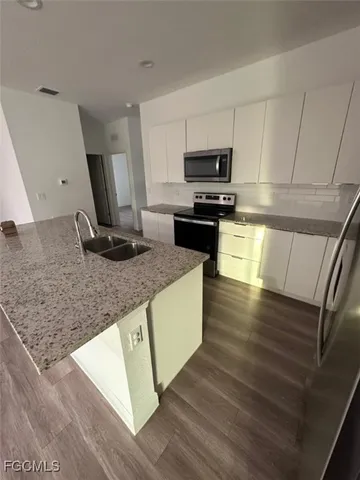 a kitchen with stainless steel appliances granite countertop a sink stove and microwave