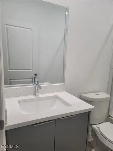 a bathroom with a sink a toilet and mirror