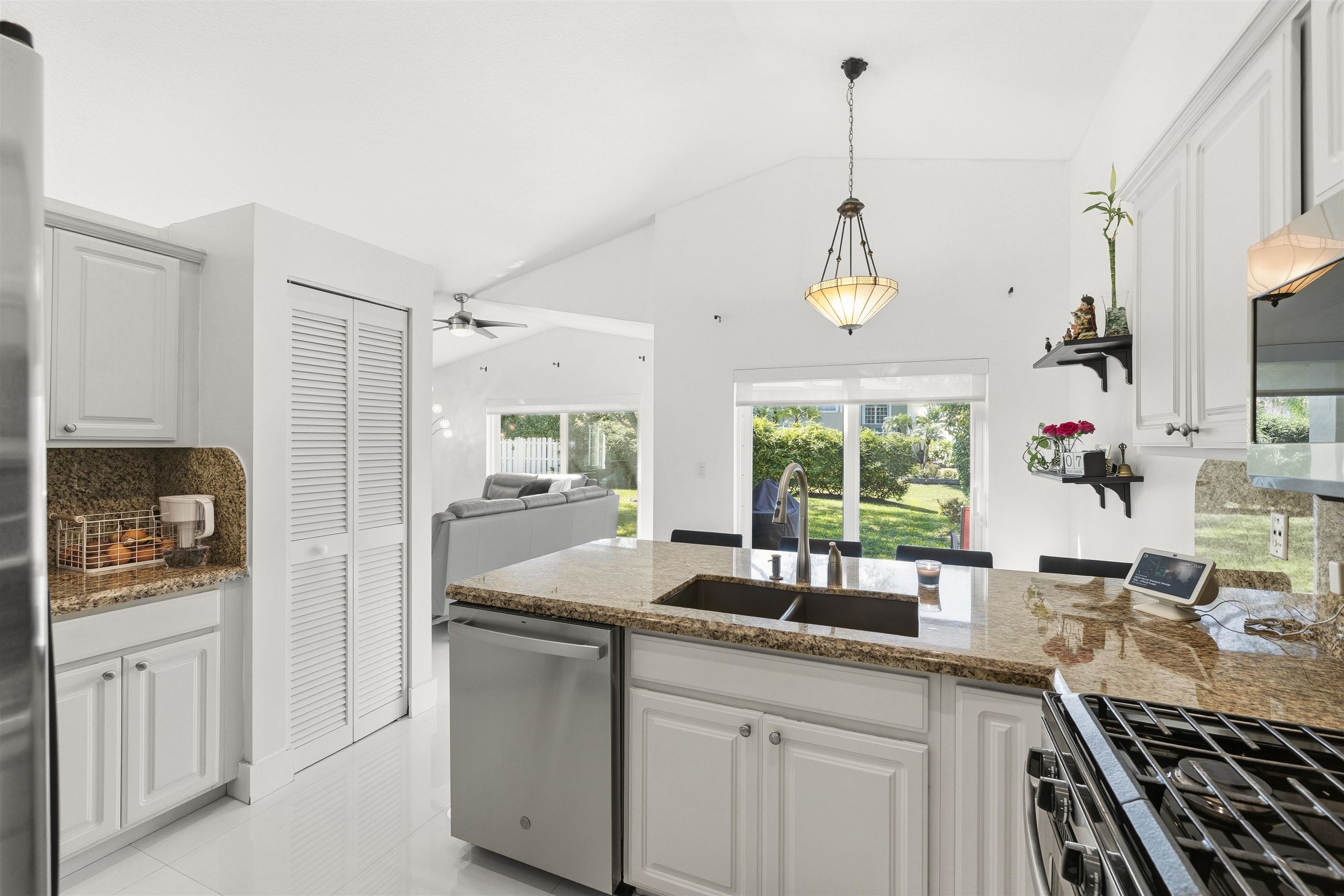 75 Gables Boulevard Weston, FL 33326 - Photo 28 of 29 Kitchen with white cabinets, vaulted ceiling, stainless steel appliances, a peninsula, and open floor plan