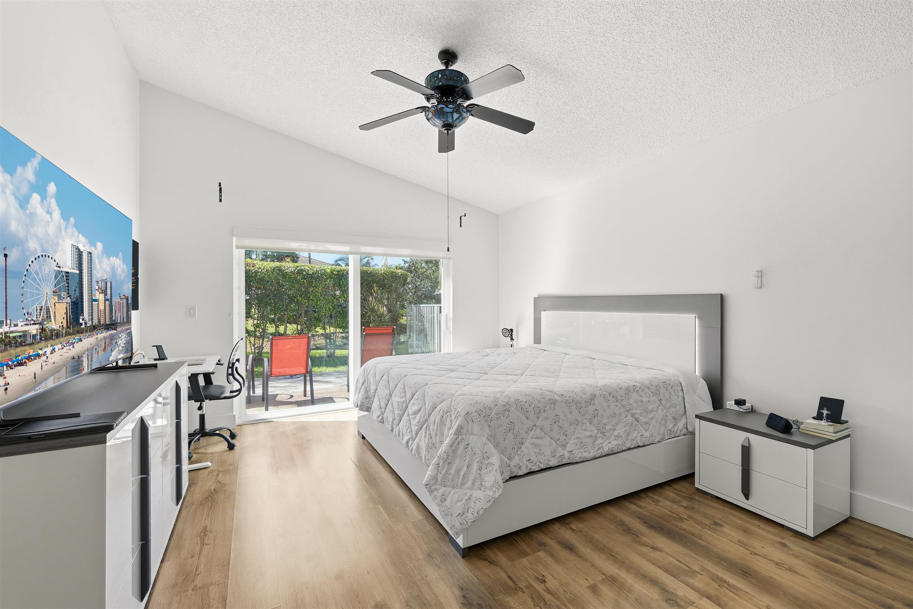75 Gables Boulevard Weston, FL 33326 - Photo 12 of 29 Bedroom featuring a textured ceiling, access to outside, light wood-style flooring, a ceiling fan, and an office area