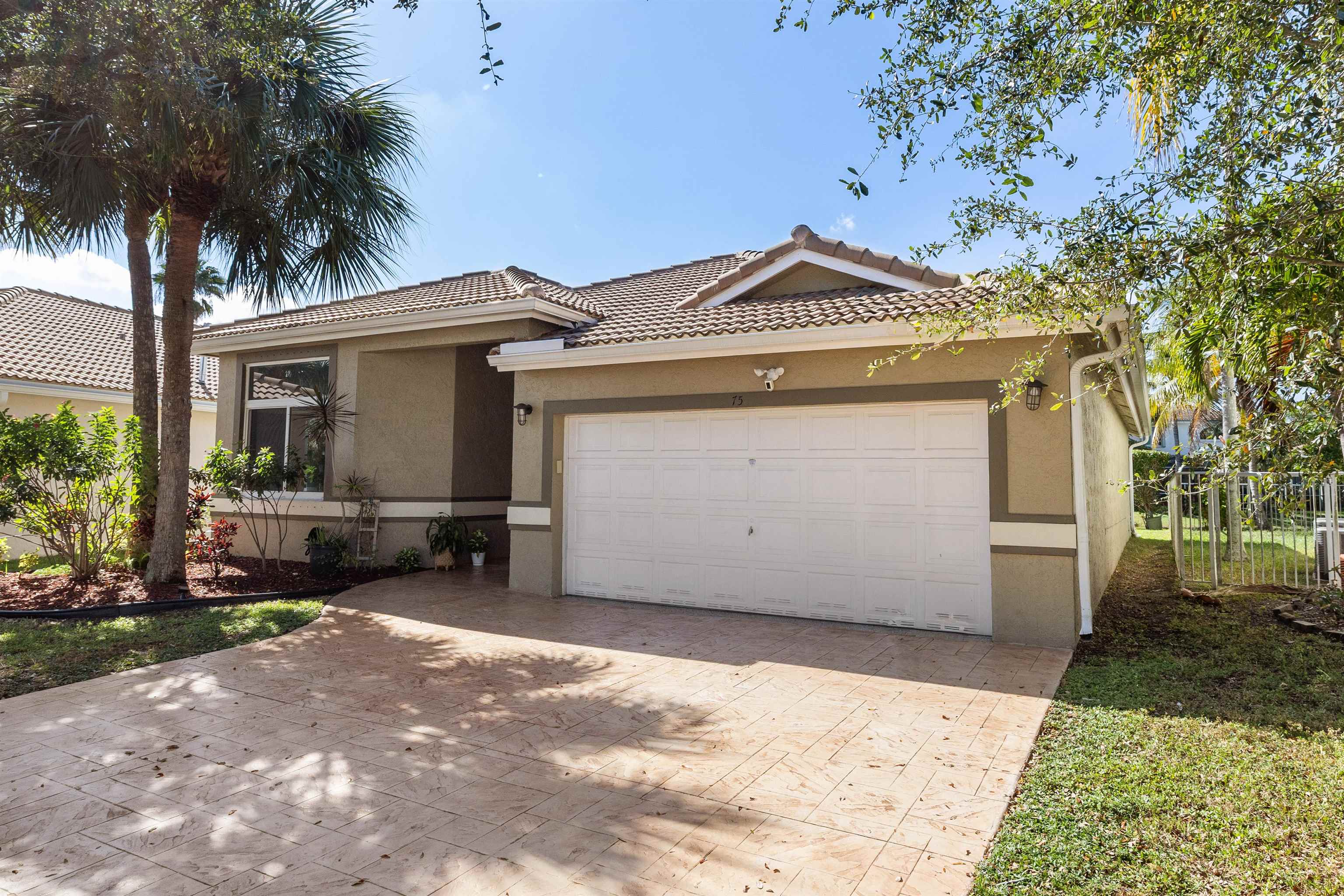 75 Gables Boulevard Weston, FL 33326 - Photo 25 of 29 Single story home with stucco siding, decorative driveway, a tile roof, and an attached garage