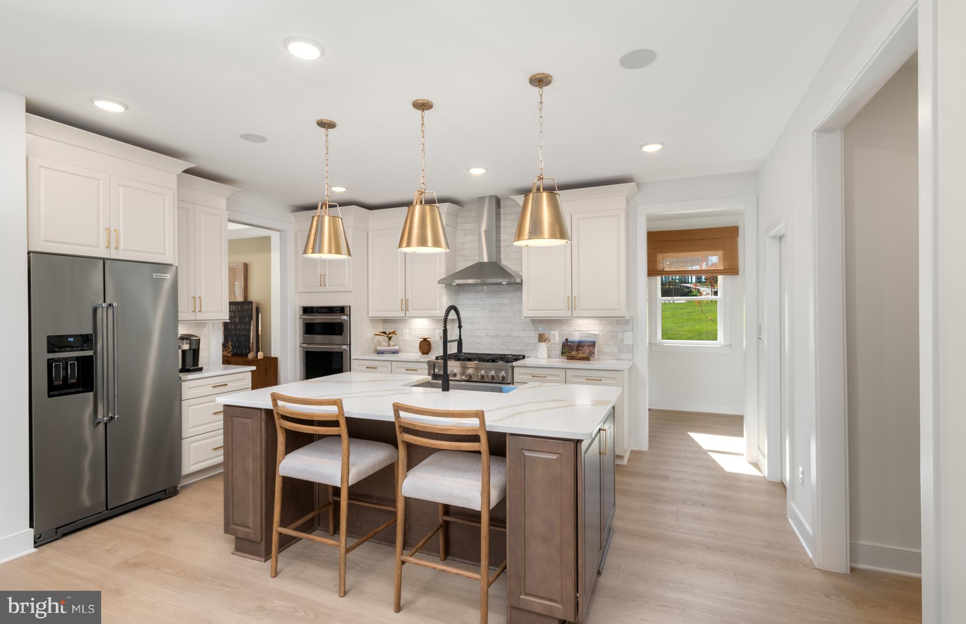18279 Cresswell Rst Lane Leesburg, VA 20176 - Photo 20 of 60 a kitchen with stainless steel appliances kitchen island granite countertop a refrigerator a stove a sink a dining table and chairs with wooden floor