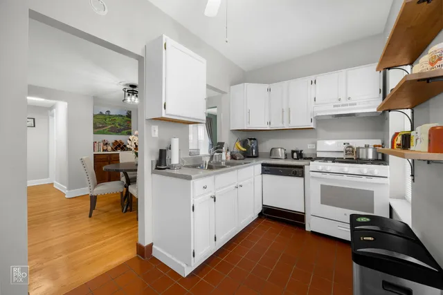 a kitchen with white cabinets and appliances