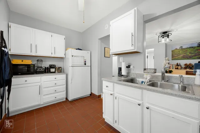 a kitchen with cabinets appliances a sink and a counter top space