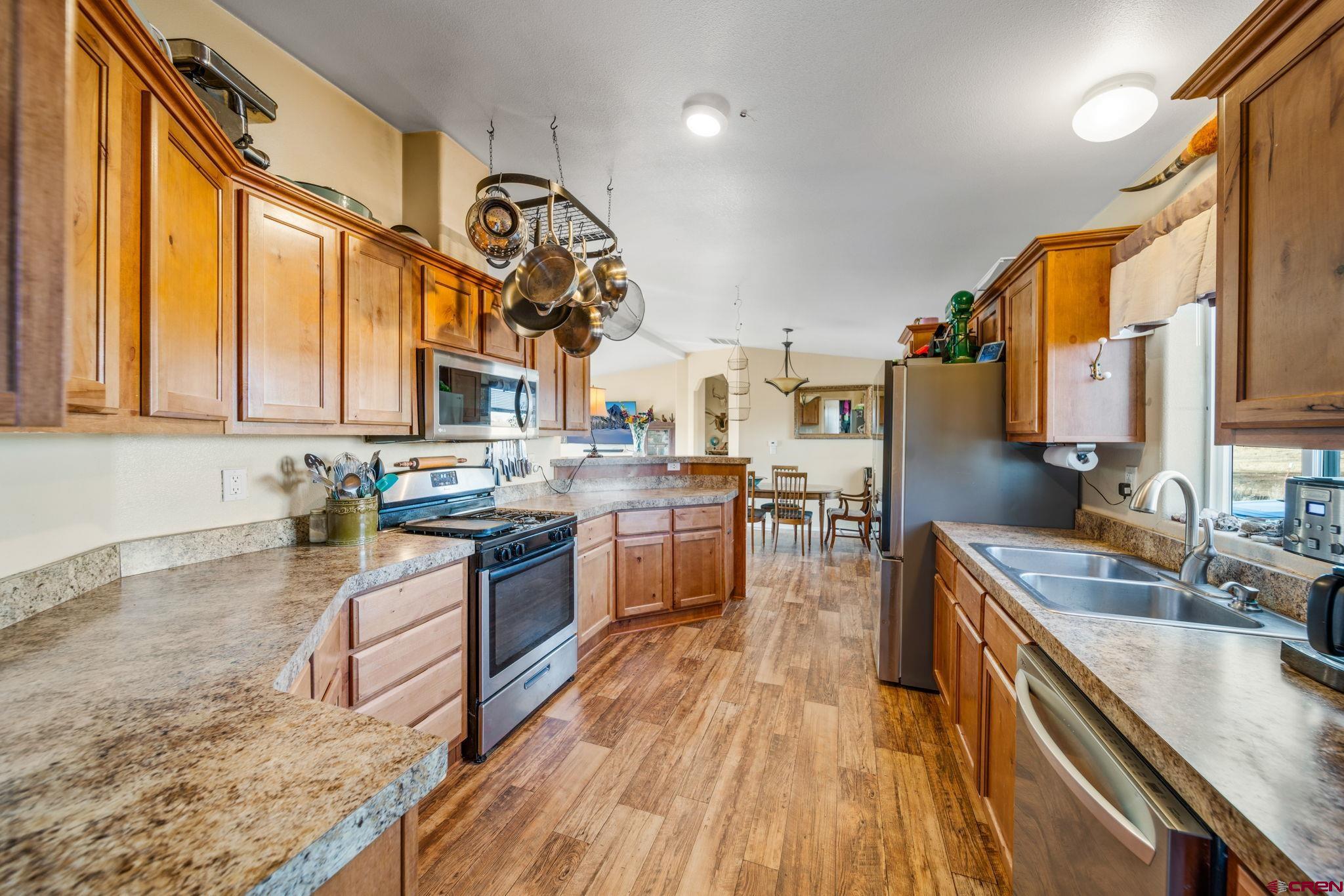 75 Sundial Lane Ignacio, CO 81137 - Photo 6 of 31 a kitchen with stainless steel appliances granite countertop wooden cabinets a stove top oven a sink and dishwasher