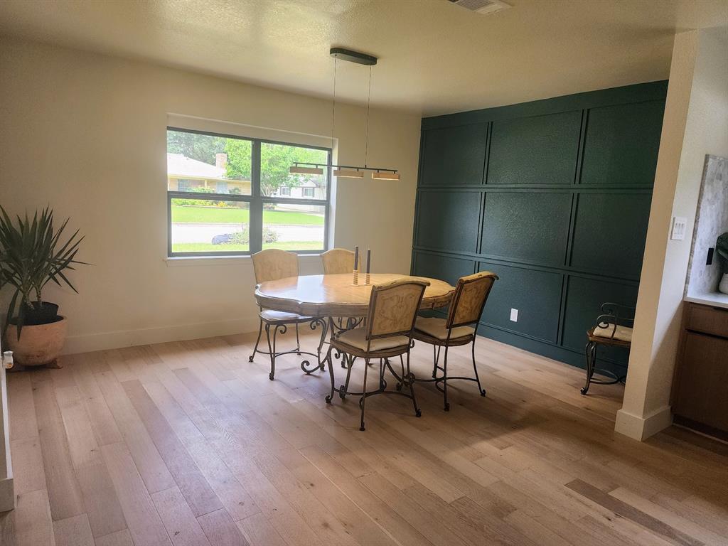 2908 Washington Street Commerce, TX 75428 - Photo 18 of 29 Light wood-finish flooring complements a distinctive accent wall with panel detailing