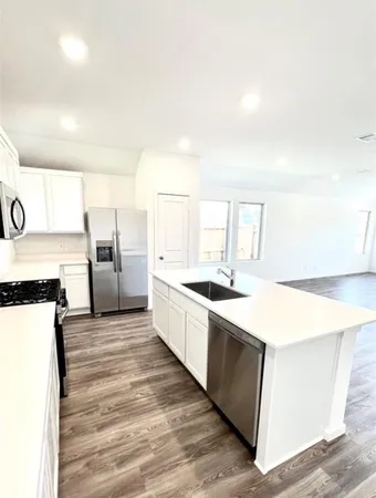 a large kitchen with cabinets and stainless steel appliances