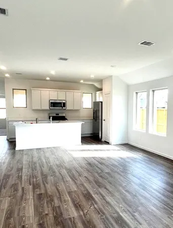 a large kitchen with a refrigerator and a stove top oven