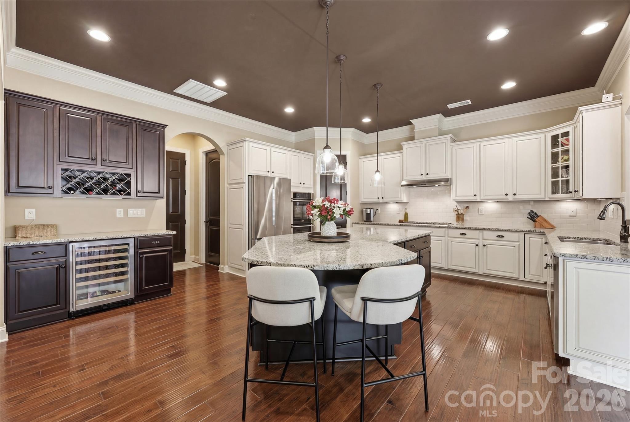 8094 Clems Branch Road Indian Land, SC 29707 - Photo 12 of 38 a kitchen with stainless steel appliances kitchen island granite countertop a refrigerator a stove a sink a dining table and chairs with wooden floor