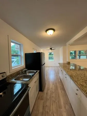 a kitchen with granite countertop a stove and a sink
