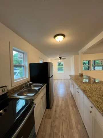 a kitchen with granite countertop a stove and a sink