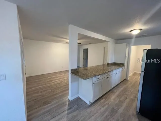 a kitchen with granite countertop a stove and a refrigerator