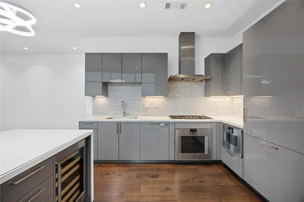 a view of a hallway with wooden floor and a bathroom