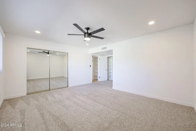 an empty room with a ceiling fan and bathroom