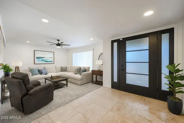 a living room with furniture potted plant and kitchen view